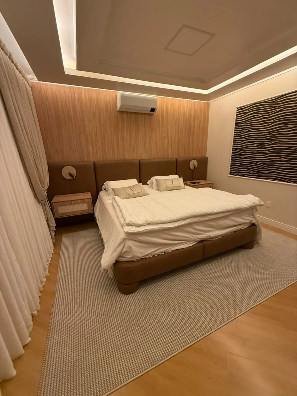 Quarto com cama e cabeceira estofadas em couro caramelo